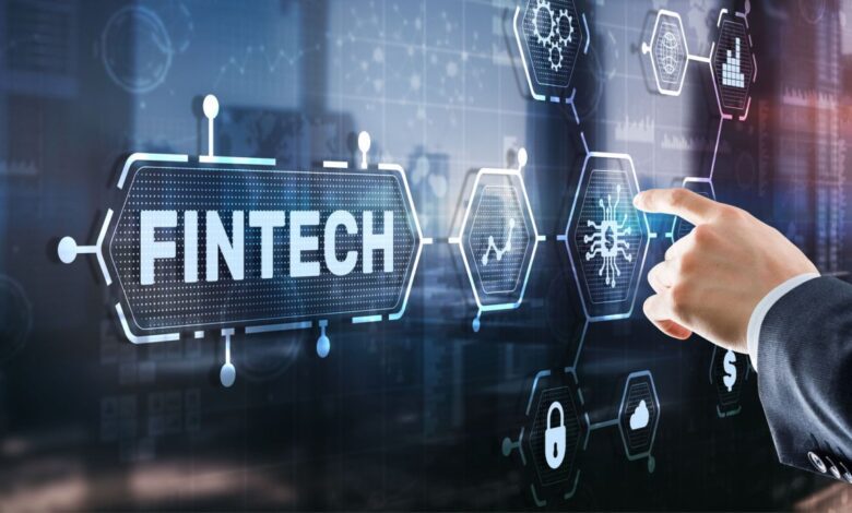 Businessman's arm and finger pointing at a Fintech sign.