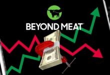 Beyond Meat logo with up and down stock chart arrows on smartphone background.